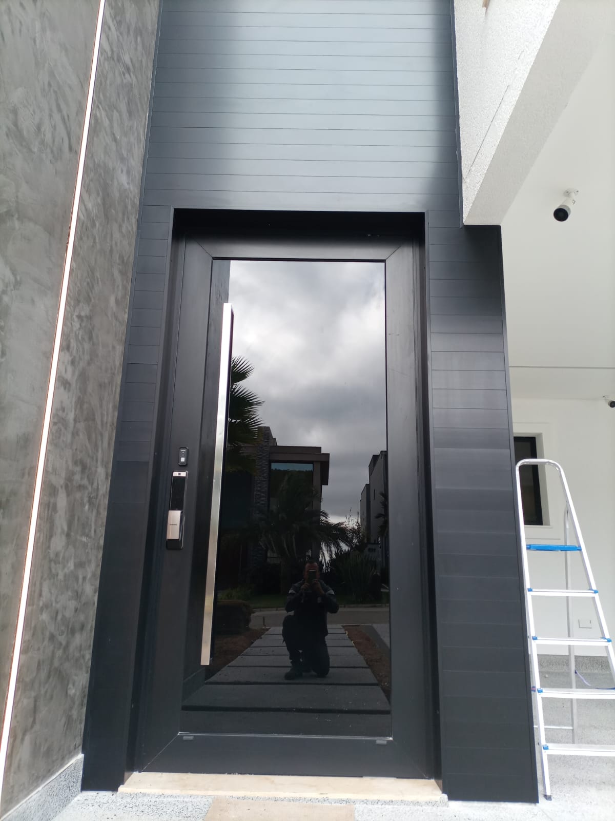Porta pivotante em alumínio grafite instalada pela Nova Lux